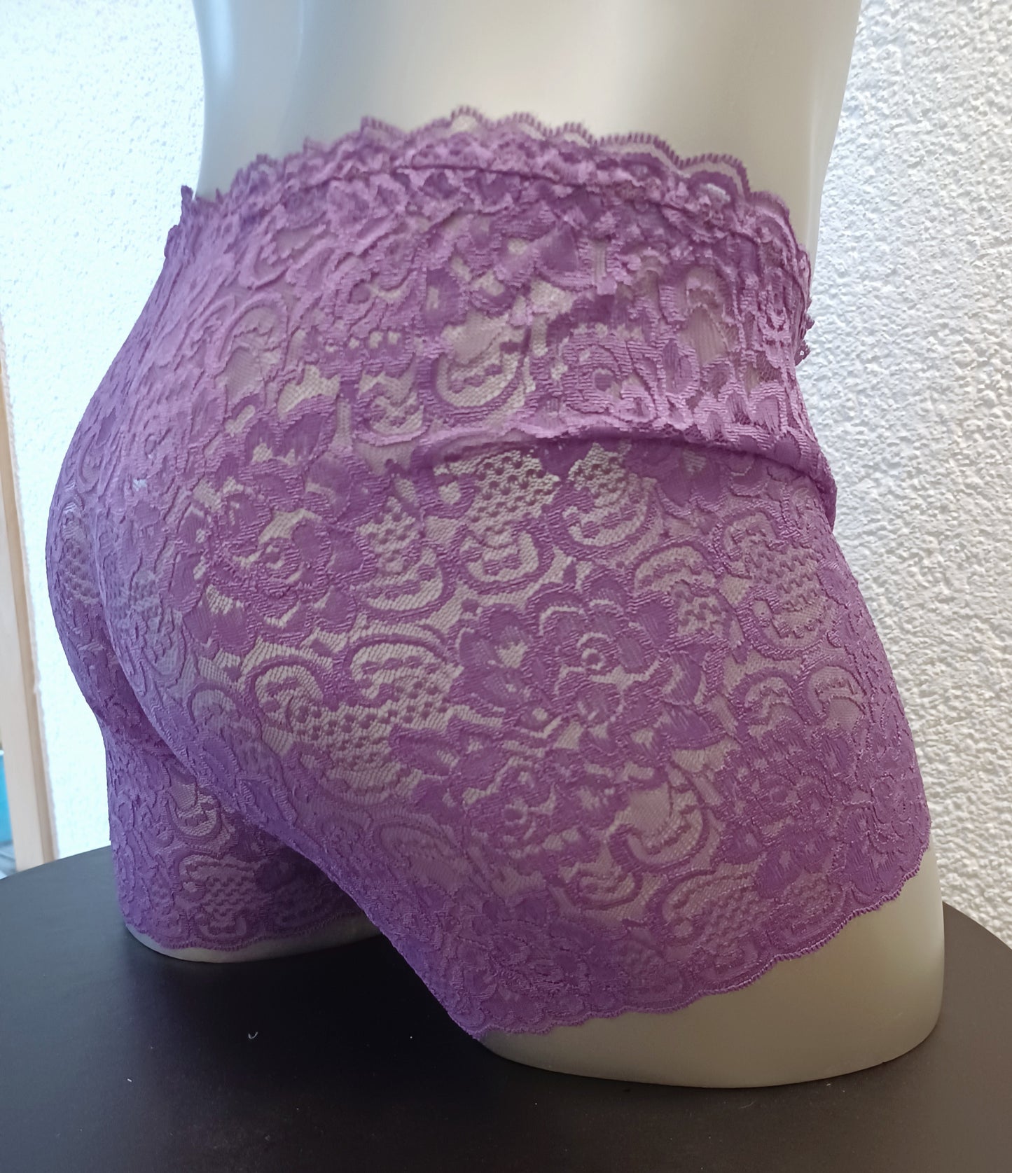 Edle, feminine Boxershorts in lila aus zarter elastischer transparenter Spitze. Der Bund und die Bein haben eine Bogenabschlusskante. Push-up und Silikon Cockring werden auf Wunsch eingearbeitet.