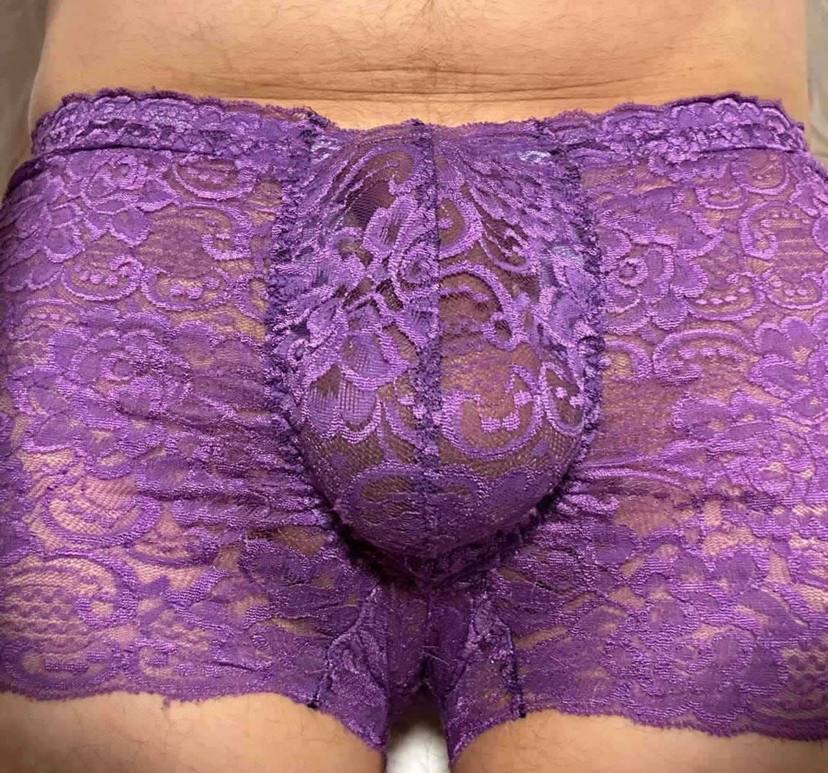 Edle, feminine Boxershorts in lila aus zarter elastischer transparenter Spitze. Der Bund und die Bein haben eine Bogenabschlusskante. Push-up und Silikon Cockring werden auf Wunsch eingearbeitet.