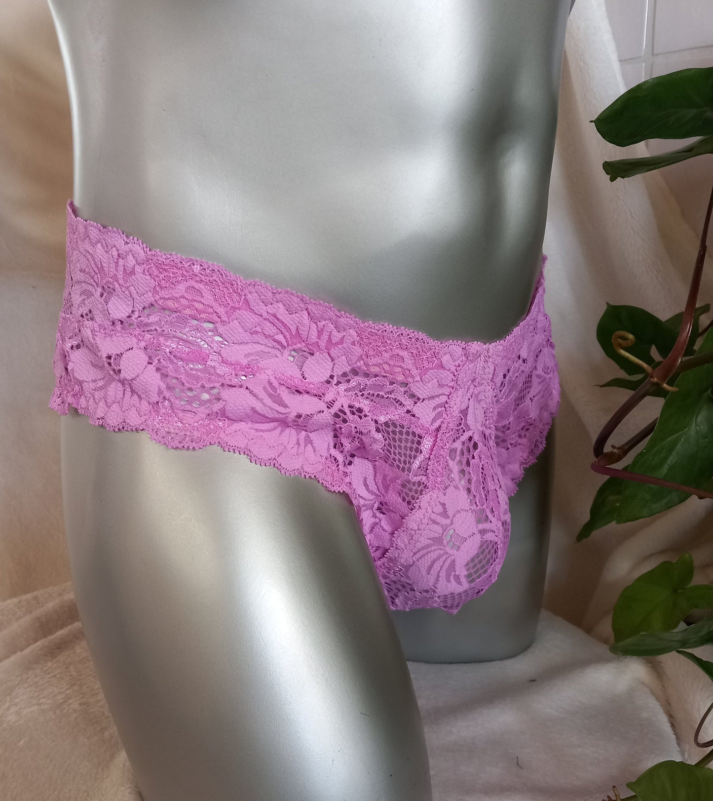 Herren-Spitzenslip aus pink farbener elastischer Spitze. Der ausgefeilte Designerschnitt ermöglicht Spitzenbögen rings um den Hipster