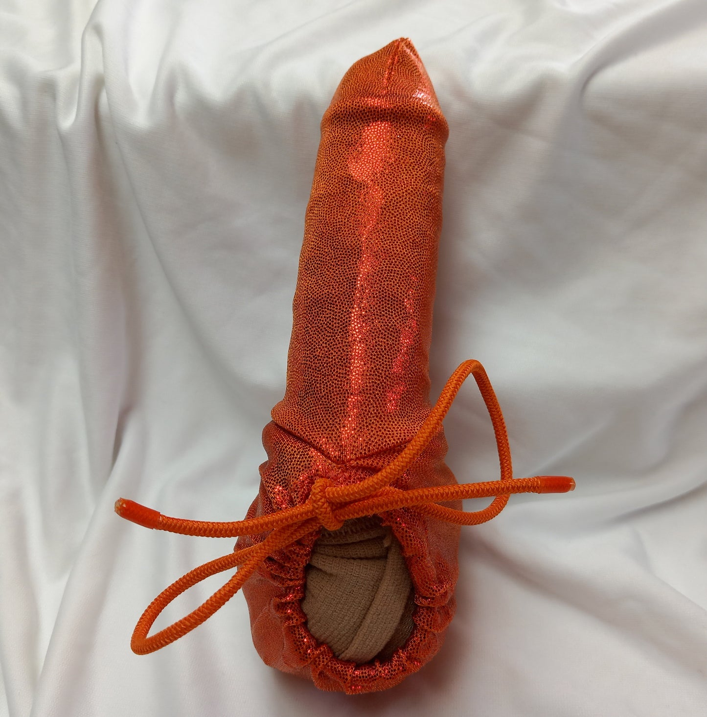Penissocke aus elastischem Lycra in orange Metallic. Vorne geschlossen mit Gummibändel zum Schnüren