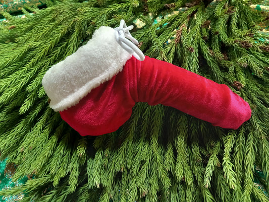 Penissocke aus elastischem Samt Lycra in rot mit weißem Plüschrand für weihnachtlichen Look. Vorne geschlossen mit Gummibändel zum Schnüren