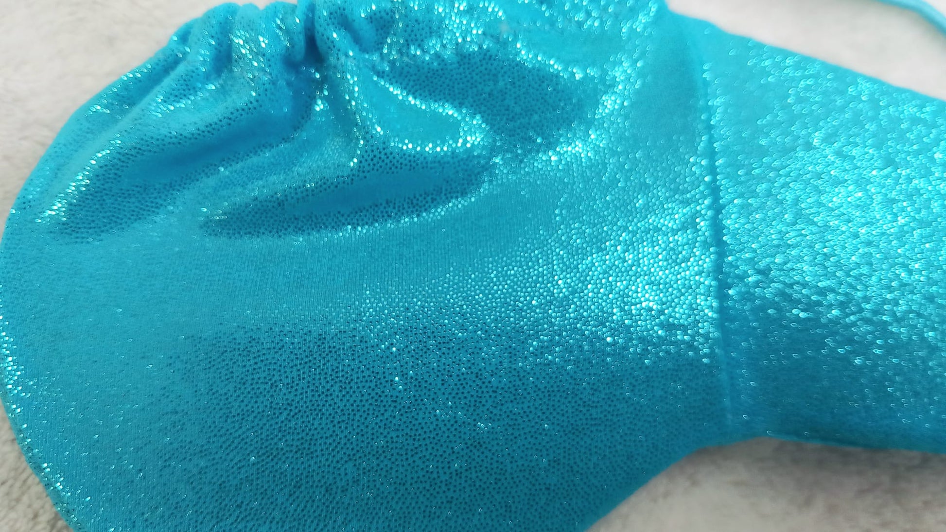 Penissocke aus elastischem Lycra in türkis mit Metallic Effekt. Vorne geschlossen mit Gummibändel zum Schnüren